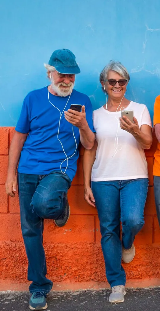 Fröhliche Menschen lehnen an Mauer.