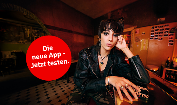Bild mit Frau am Tresen und Aufschrift - Die neue App. Jetzt testen.