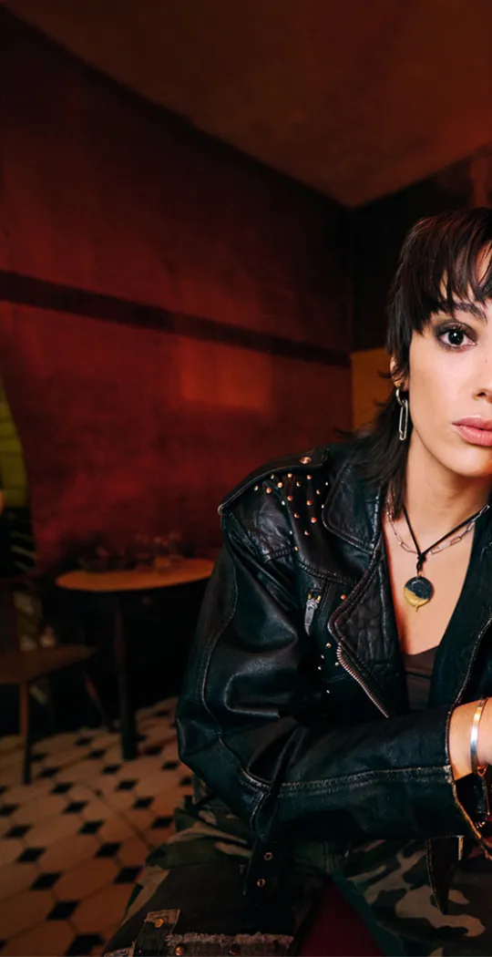 Frau sitzt an Theke.