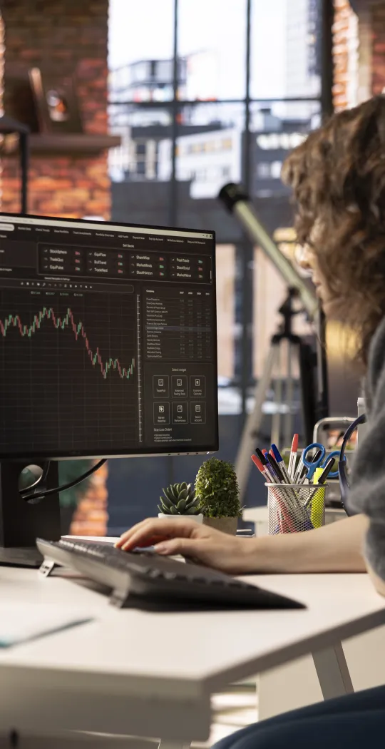 Frau analysiert am Monitor Charts