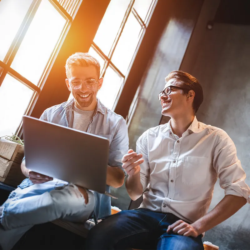 Zwei Männer sitzen auf einem Tisch und sind im Gespräch miteinander. Zwei Männer sitzen auf einem Tisch und sind im Gespräch miteinander.