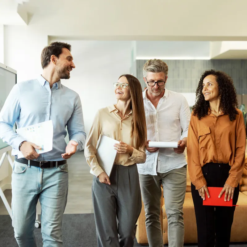 Gruppe von Kollegen unterhält sich beim Gehen. 