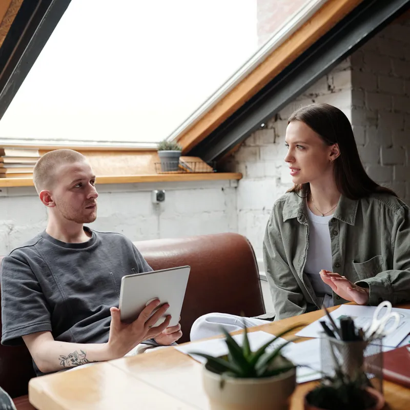 Junges paar sitzt gemeinsam am Tisch. 