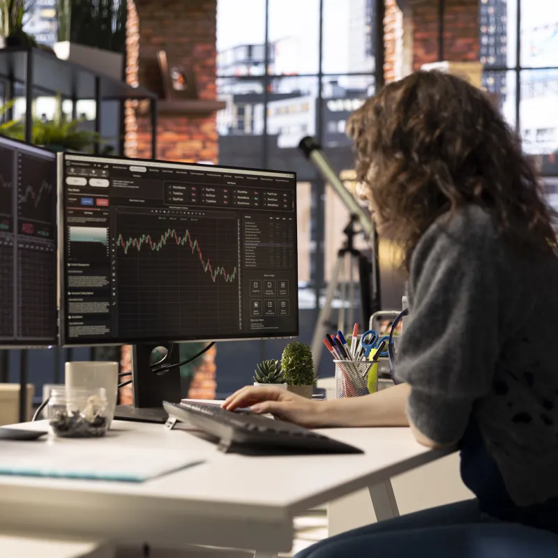 Frau analysiert am Monitor Charts